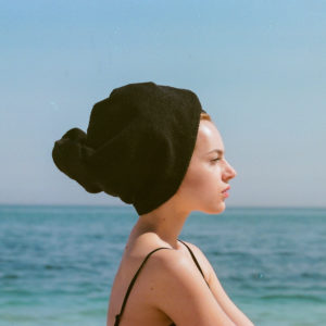 Profilo di modella con asciugamano turbante, di fronte al mare, fotografia di moda, analogica